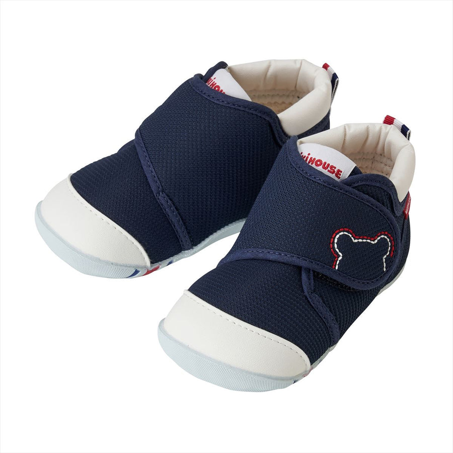 Navy first walker shoes with wide straps and rounded toes.