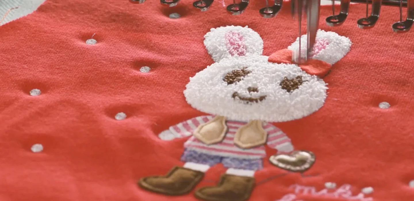 A rabbit character is embroidered onto red MIKI HOUSE fabric
